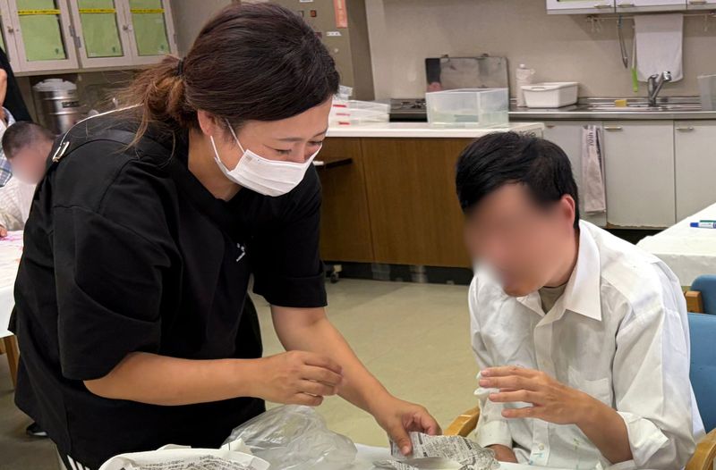 職員と利用者が創作活動に取り組む様子